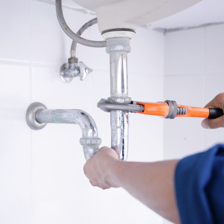 Plumber fixing the downpipes on a sink